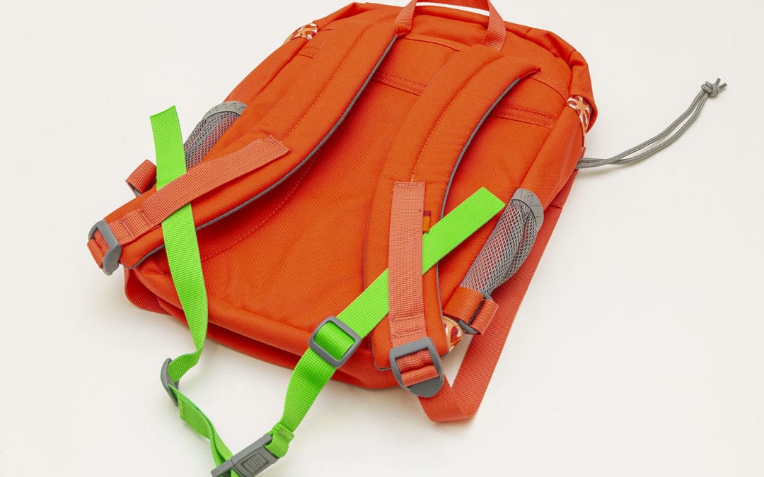 Voici comment je refile la sangle de poitrine sur le sac à dos d’un enfant.